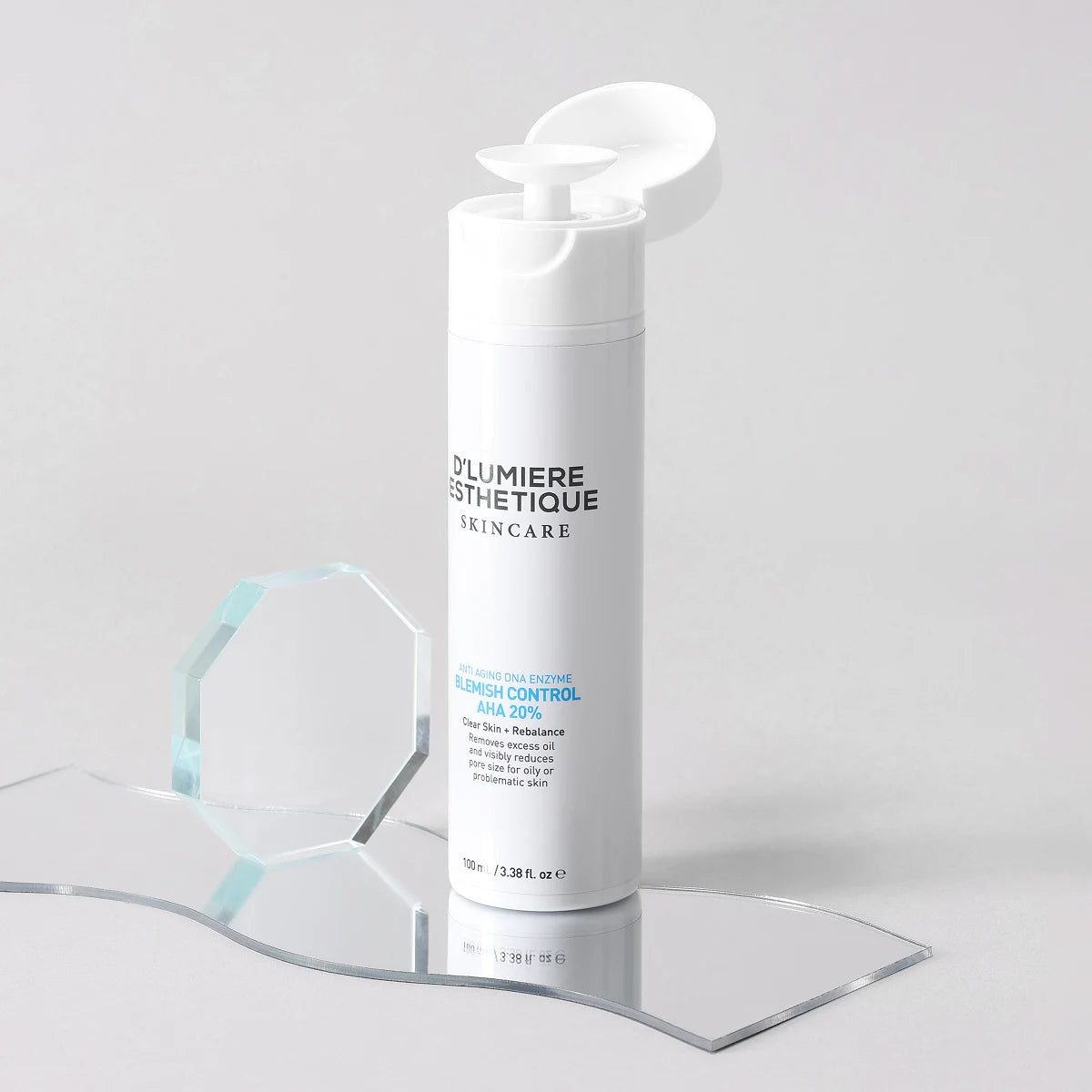 Skincare bottle with 'D'Lumiere Esthetique' branding on a clear stand against a light gray background