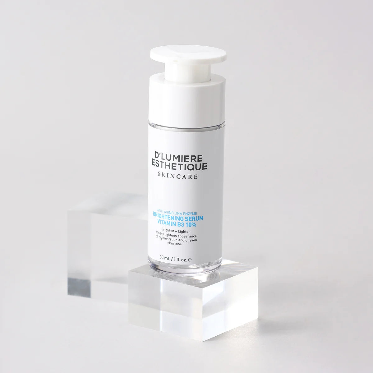 Skincare serum bottle on a clear stand with a white background