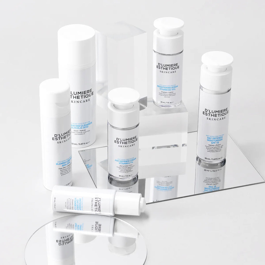 Collection of skincare products from D' Lumiere Esthetique on a reflective surface with a light gray background.