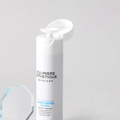 Skincare bottle with pump labeled 'D'lumiere Esthetique' on a light gray background
