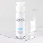 Skincare bottle labeled 'D'Lumiere Esthetique' on a clear stand with a white background