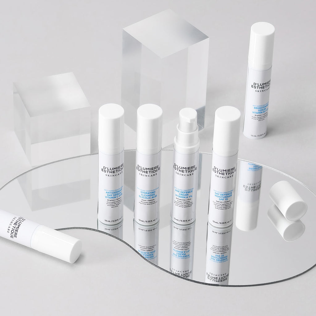 Set of skincare products on a reflective surface with a white background